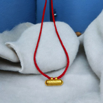 Five golden metal cylindrical taweez neatly arranged with Bhojpatra sheets on a clean white surface