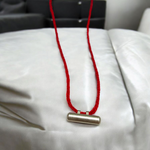 Five silver-plated cylindrical taweez amulets with accompanying Bhojpatra sheets placed neatly on a white surface