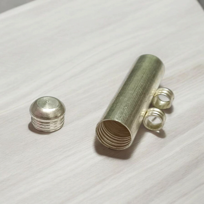 Five silver-plated cylindrical taweez amulets with accompanying Bhojpatra sheets placed neatly on a white surface