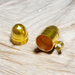 Five stylish cylindrical copper and golden metal taweez displayed with Bhojpatra sheets on a clean background