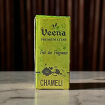Glass bottle of 2ML Chameli Attar by Veena, adorned with a golden cap and floral-themed label, surrounded by jasmine flowers on a wooden surface
