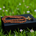 Gold-wired Rudraksha mala with 8mm beads, featuring a silver-tone Trishul pendant, arranged neatly on a dark wooden background