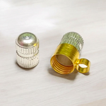 Golden and silver taweez set displayed with a Bhojpatra sheet on a wooden background