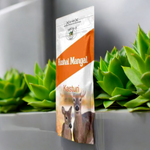 Hand-rolled Kasturi incense sticks with traditional Indian packaging placed beside a lit diya and fresh marigold flowers