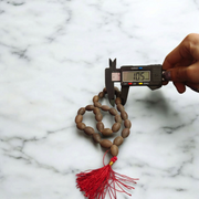 Handcrafted Kamal Gutta Mala made from natural lotus seed beads, available in 27+1 and 108+1 bead variants with a spiritual guru bead and certificate