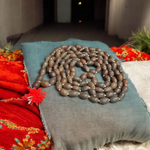 Handcrafted Kamal Gutta Mala made from natural lotus seed beads, available in 27+1 and 108+1 bead variants with a spiritual guru bead and certificate