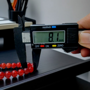 Handcrafted Red Hakik Mala made with natural Red Agate beads in 27+1 and 108+1 variants, placed on a wooden surface with lab certificate