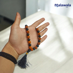 Handcrafted Rudraksha and Black Hakik mala with 5 Mukhi Rudraksha beads, used for protection, grounding, and meditation, available in 27+1 and 108+1 variants