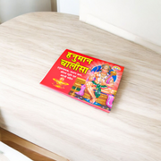 Hanuman Chalisa Hindi Book with colourful pages and devotional cover art placed near diya and flowers