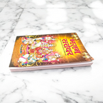 Image of Bhajan Sarover Book in Hindi with vibrant cover and devotional design placed on a wooden prayer table
