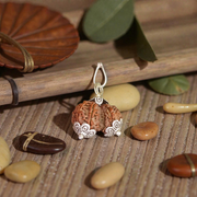 Image of Garbh Gauri Rudraksha twin bead with natural brown texture, placed on a silk cloth with traditional background