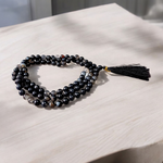 Image of Natural Sulemani Hakik (Black Agate) Mala with 108+1 and 27+1 polished 8mm round beads, displayed on a white background