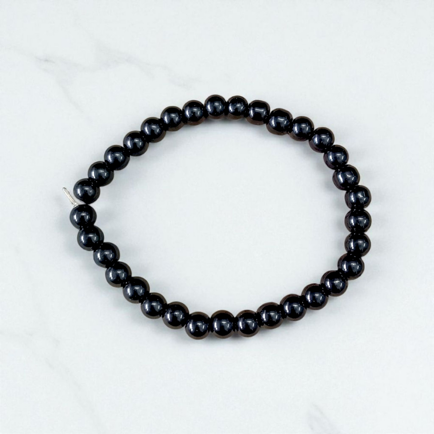 Image of a Black Agate (Black Hakik) bracelet with 6mm round beads arranged on a stretchable cord