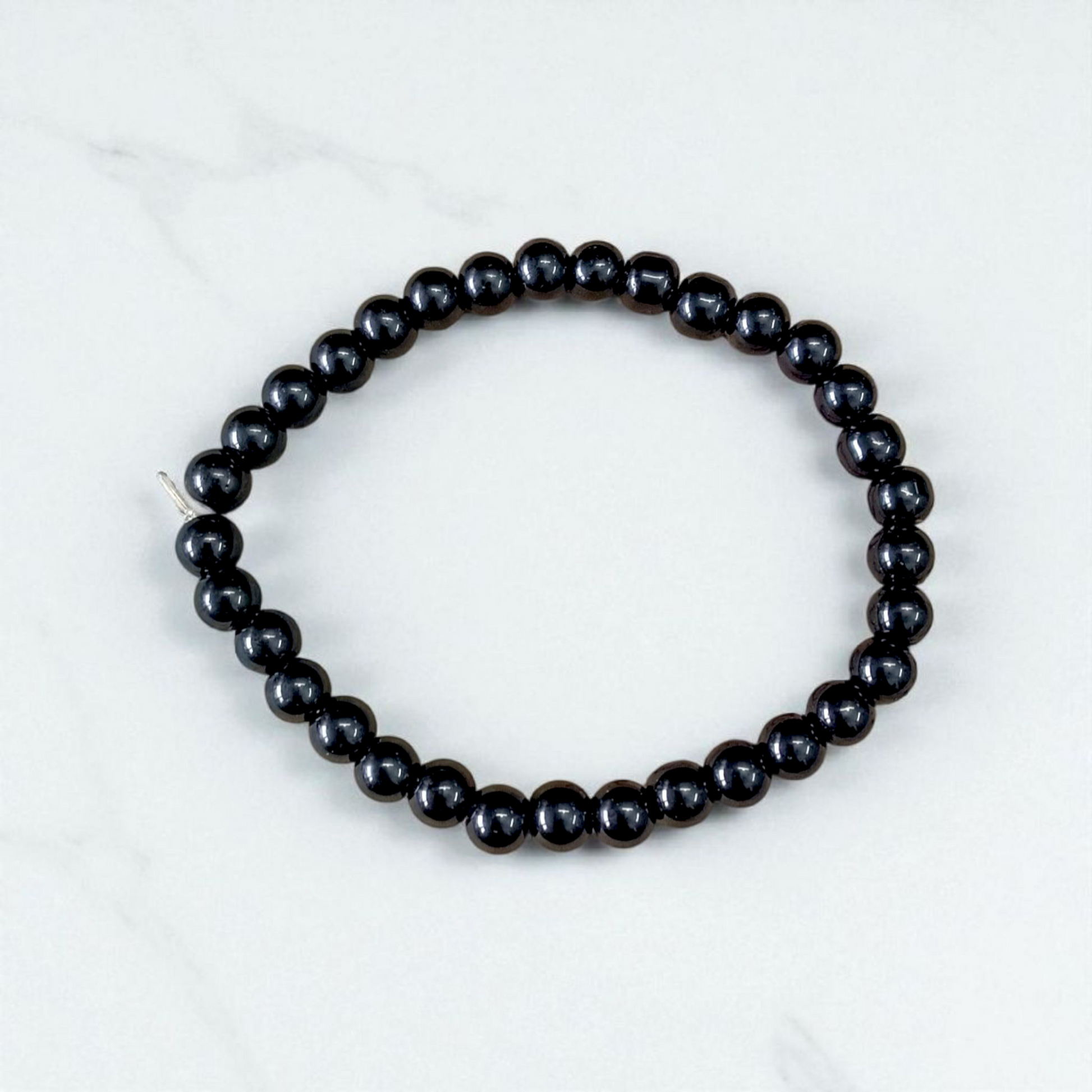 Image of a Black Agate (Black Hakik) bracelet with 6mm round beads arranged on a stretchable cord