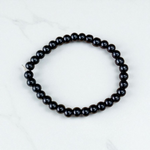 Image of a Black Agate (Black Hakik) bracelet with 6mm round beads arranged on a stretchable cord