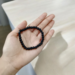 Image of a Black Agate (Black Hakik) bracelet with 6mm round beads arranged on a stretchable cord