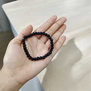 Image of a Black Agate (Black Hakik) bracelet with 6mm round beads arranged on a stretchable cord