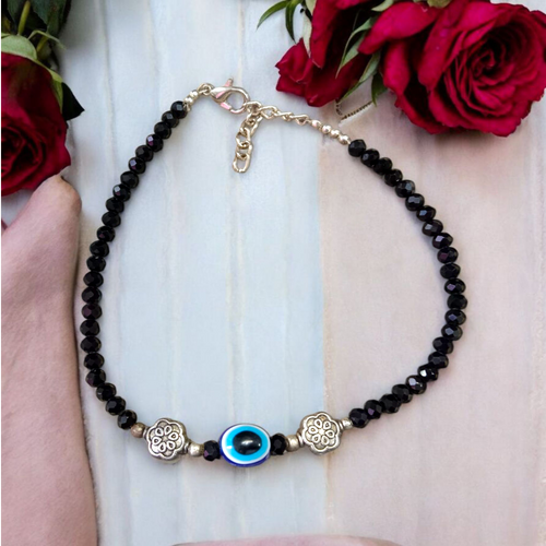 Image of a handcrafted black crystal beads anklet with a central evil eye charm, designed for unisex wear and spiritual protection