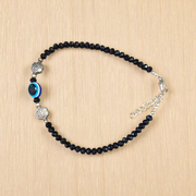 Image of a handcrafted black crystal beads anklet with a central evil eye charm, designed for unisex wear and spiritual protection
