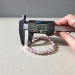 Image of a natural Amethyst bracelet with polished 8mm deep purple beads, arranged in a circular shape on a light background