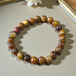 Image of a natural Tiger Eye bracelet made of 8mm golden-brown beads with a silky shine, arranged in a circular shape on a neutral background