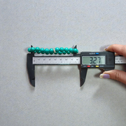 Image of a natural turquoise bracelet with polished 8mm round blue beads and black veining, displayed in a circular shape on a plain background
