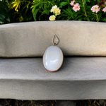 Image of a polished oval Natural Milky Moonstone Pendant on a black adjustable cotton thread, displayed on a neutral background