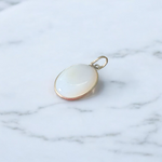 Image of a polished oval Natural Milky Moonstone Pendant on a black adjustable cotton thread, displayed on a neutral background