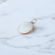 Image of a polished oval Natural Milky Moonstone Pendant on a black adjustable cotton thread, displayed on a neutral background