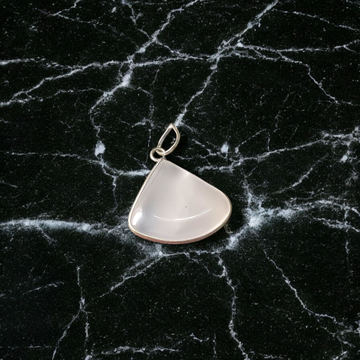 Image of a polished oval Natural Milky Moonstone Pendant on a black adjustable cotton thread, displayed on a neutral background