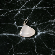 Image of a polished oval Natural Milky Moonstone Pendant on a black adjustable cotton thread, displayed on a neutral background