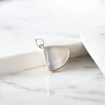 Image of a polished oval Natural Milky Moonstone Pendant on a black adjustable cotton thread, displayed on a neutral background