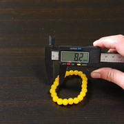 Image of a stretchable Yellow Onyx bracelet with polished 8mm round beads arranged in a circle on a white or neutral background