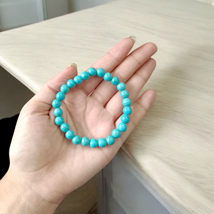 Image of a stretchable turquoise gemstone bracelet made with smooth 8mm beads on a white background