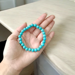 Image of a stretchable turquoise gemstone bracelet made with smooth 8mm beads on a white background