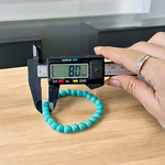 Image of a stretchable turquoise gemstone bracelet made with smooth 8mm beads on a white background