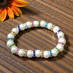 Image of an original pearl bracelet with smooth, polished 8mm white pearls arranged in a circle on a soft neutral background