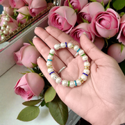 Image of an original pearl bracelet with smooth, polished 8mm white pearls arranged in a circle on a soft neutral background