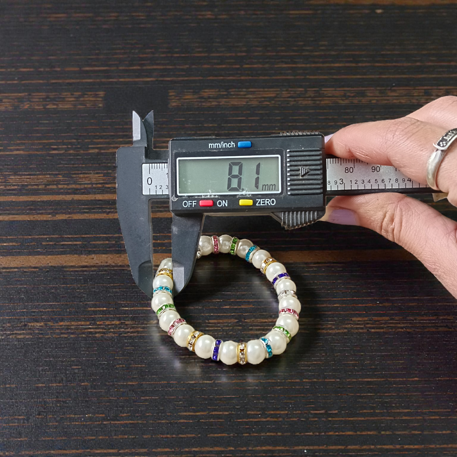 Image of an original pearl bracelet with smooth, polished 8mm white pearls arranged in a circle on a soft neutral background
