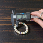Image of an original pearl bracelet with smooth, polished 8mm white pearls arranged in a circle on a soft neutral background
