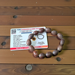 Image of two adjustable spiritual bracelets – one made with white Vaijanti seeds and the other with brown Kamal Gutta beads – displayed on a natural surface