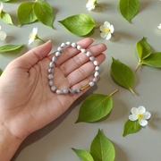 Image of two stretchable bracelets – one made with white Vaijanti seeds and one with yellow Haldi beads – arranged side by side on a natural background