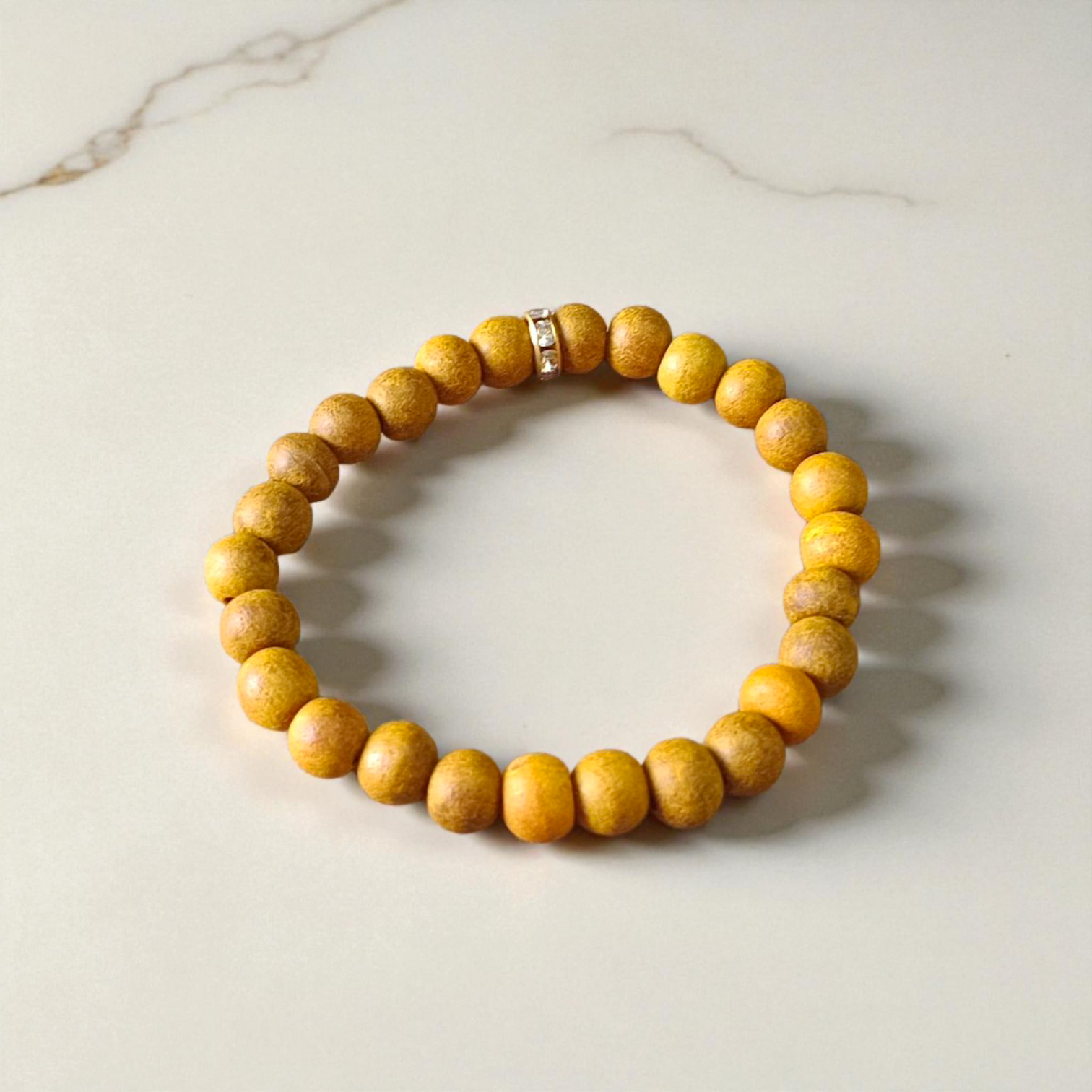 Image of two stretchable bracelets – one made with white Vaijanti seeds and one with yellow Haldi beads – arranged side by side on a natural background