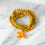 Image showing a combo of Kamal Gutta Mala and Haldi Mala with 108+1 beads, handcrafted and lab certified, placed on a spiritual cloth background