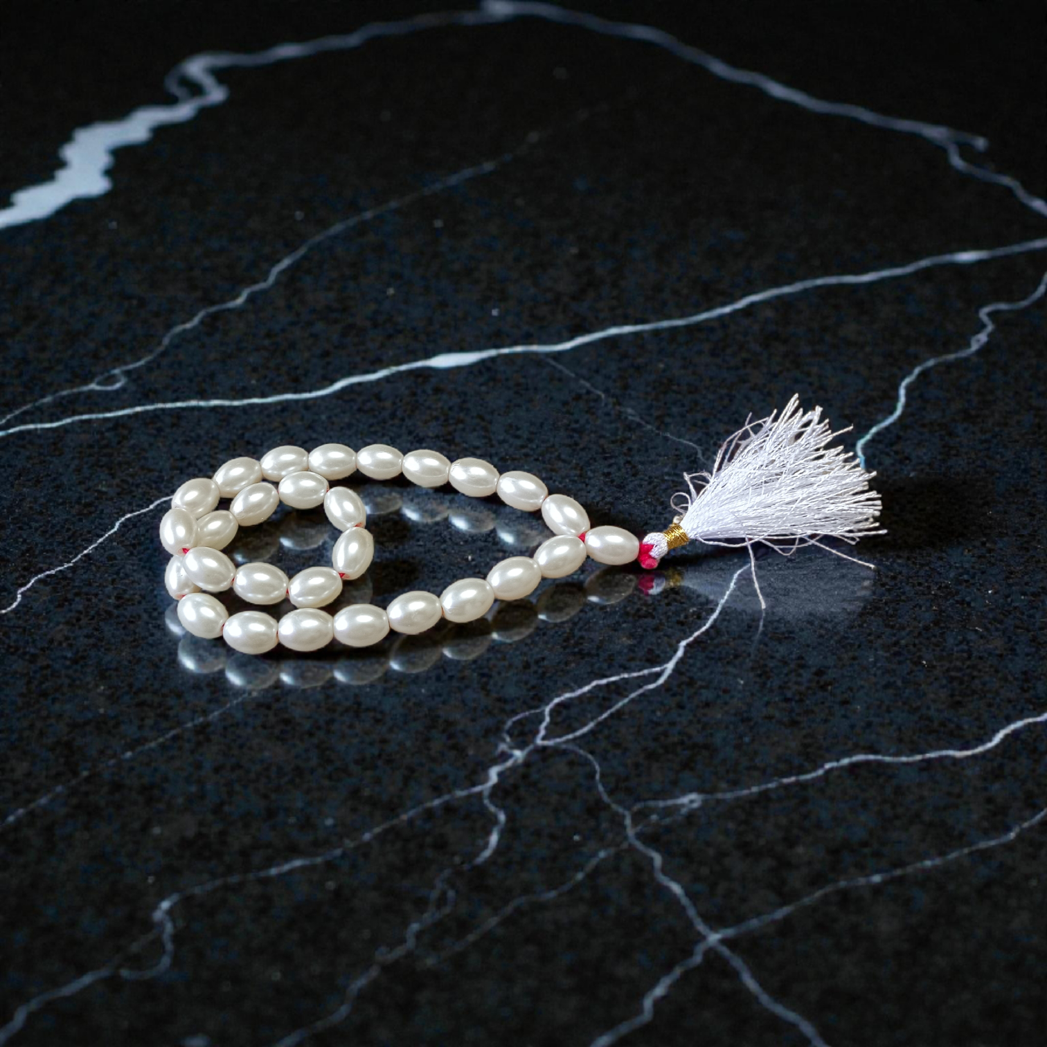 Image showing a hand-knotted Moti Mala made of smooth, white natural pearls with a central guru bead, placed on a sacred cloth for worship