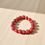 Image showing a stretchable 5 Mukhi Rudraksha bracelet made with 11mm natural brown beads, arranged in a circle on a plain background