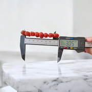 Image showing a stretchable 5 Mukhi Rudraksha bracelet made with 11mm natural brown beads, arranged in a circle on a plain background