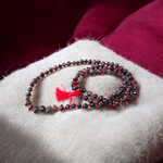 Image showing combo of Lal Gunja Mala and Black Gunja Mala with 108+1 beads, lab certified, placed aesthetically on a spiritual cloth for rituals or meditation