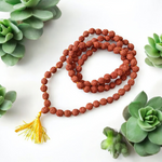 Image showing combo of brown Rudraksha Mala and Black Rudraksha Mala, each with 108+1 beads (8mm), lab certified and arranged on a spiritual cloth background