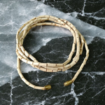 Lab-certified natural Tulsi mala with small round beads, traditionally knotted and displayed on a soft spiritual background